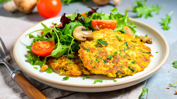 Pfannkuchen mit frischem Salat und Tomaten auf einem Teller.
