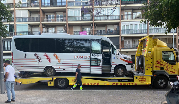 KI generiert: Ein weißer Minibus wird auf einem gelben Abschleppwagen transportiert. Text: ROMERO.