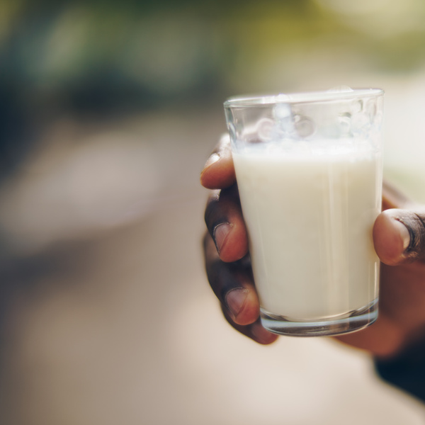 Hand mit Glas pflanzlicher Milch Ohne Muuh