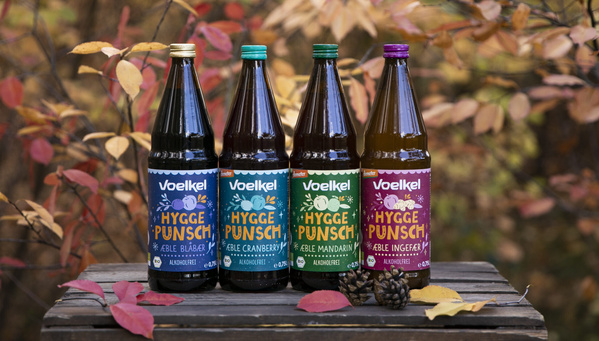 Hygge-Punsche von Voelkel auf Holzkiste vor Herbstwald-Kulisse