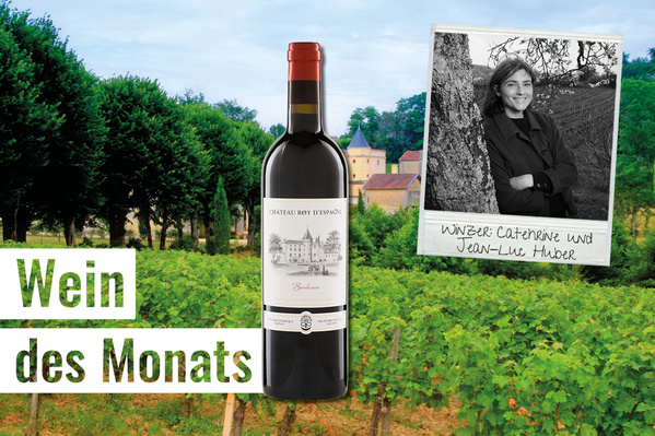 Das Bild zeigt eine Weinflasche "Château Roy d'Espagne" vor einem Weinberg. Im Hintergrund ist eine Schwarz-Weiß-Fotografie von zwei Winzern, Catherine und Jean-Luc Huber, zu sehen, mit der Aufschrift "Wein des Monats".
