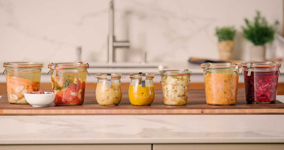 KI generiert: Verschiedene Einmachgläser mit eingelegtem Gemüse auf einer Küchenarbeitsplatte.