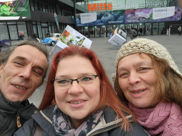 Selfie vom Grünlandteam Messebesuch Felix, Karen und Anita vorm Eingang der BIOFACH Messe