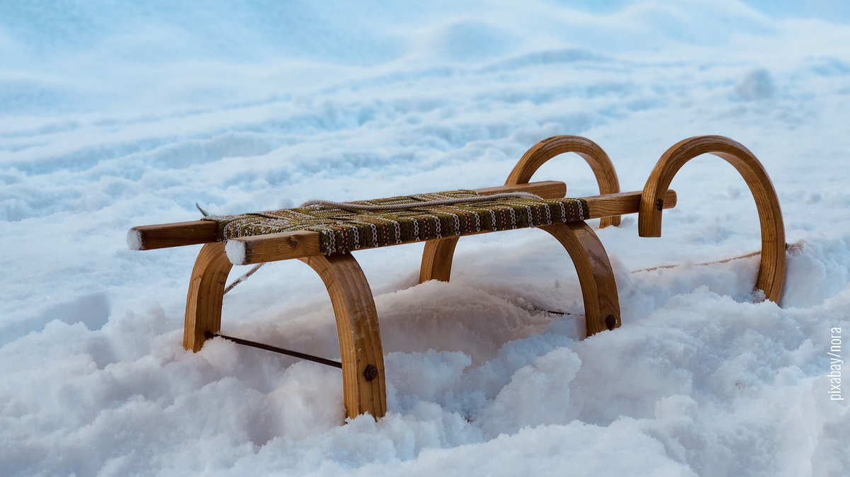 Holzschlitten im Schnee