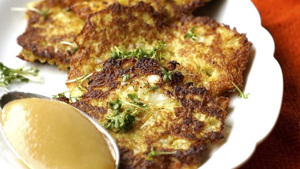 Ein kleiner Stapel Kartoffelpuffer mit einem Löffel Apfelmus